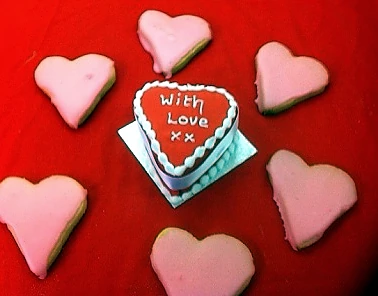 Heart-shaped Valentine biscuits arranged on a red background